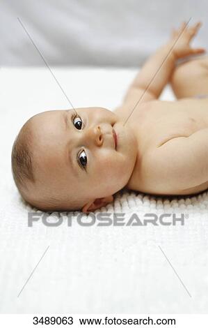 Stock Image - 8 months baby boy lying down. Fotosearch