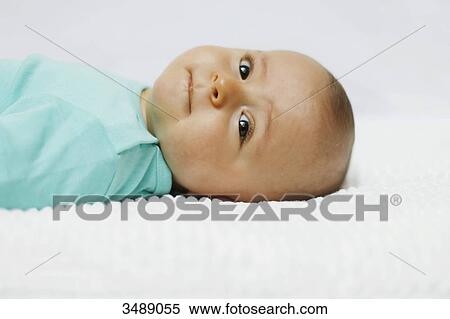 Stock Photography - 8 months baby boy lying down. Fotosearch