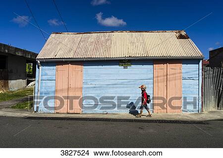 A kid in front of a house pink and blue, Saint-Louis, Marie-Galante, Guadeloupe, France View Large Photo Image Picture - A kid in front of a house pink and blue, Saint-Louis, Marie-Galante, Guadeloupe, France. Fotosearch