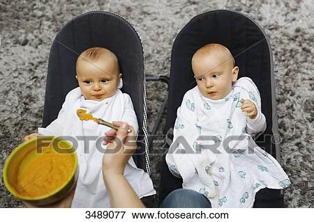 A mother feeding her 8 months baby boy twins View Large Photo Image Stock Photo - A mother feeding her 8 months baby boy twins. Fotosearch