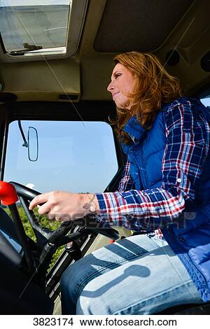 beautiful and cheerful young woman farmer driving tractor in the fields during harvest in countryside- View Large Photo Image Picture - beautiful and cheerful young woman farmer driving tractor in the fields during harvest in countryside-. Fotosearch
