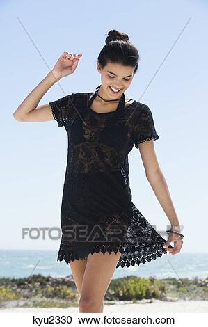 Stock Image - Beautiful woman enjoying on the beach. Fotosearch