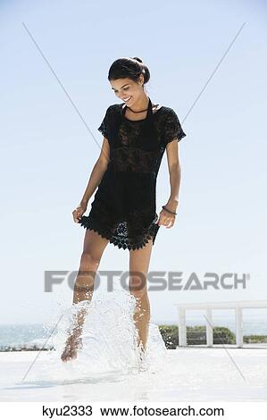 Stock Image - Beautiful woman enjoying on the beach. Fotosearch