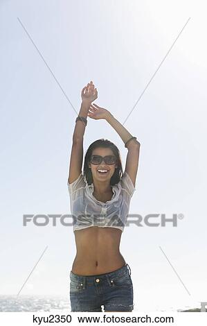 Stock Image - Beautiful woman enjoying on the beach. Fotosearch