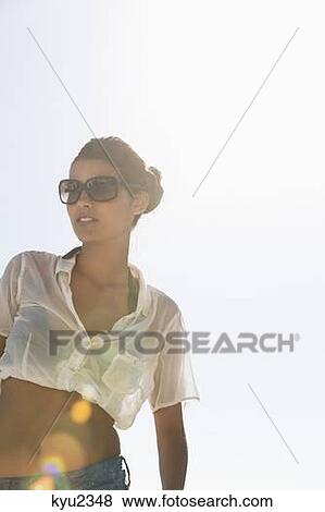 Stock Photo - Beautiful woman enjoying on the beach. Fotosearch
