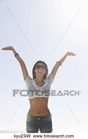 Stock Photo - Beautiful woman enjoying on the beach. Fotosearch