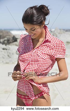 Beautiful woman getting dressed on the beach View Large Photo Image Picture - Beautiful woman getting dressed on the beach. Fotosearch