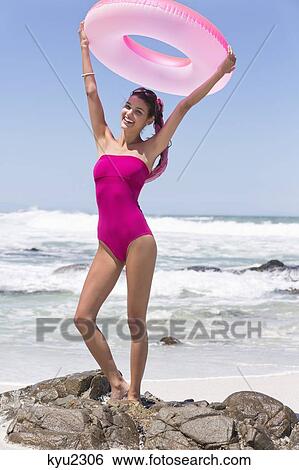 Beautiful woman holding aloft an inflatable ring on the beach View Large Photo Image Stock Photograph - Beautiful woman holding aloft an inflatable ring on the beach. Fotosearch