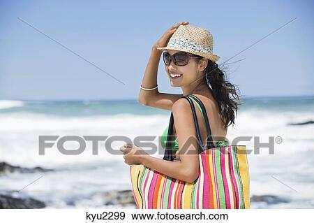 Stock Photo - Beautiful woman smiling on the beach. Fotosearch