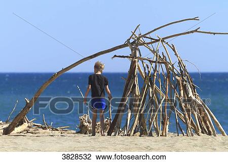 Stock Image - Boy and hut on the beach. Fotosearch