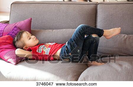 Boy lying on the couch View Large Photo Image Stock Photo - Boy lying on the couch. Fotosearch