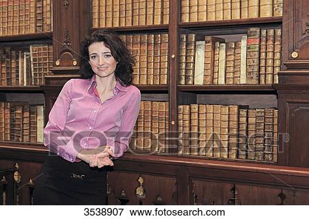 Brown-haired young woman in a library of old books. View Large Photo Image Stock Photo - Brown-haired young woman in a library of old books.. Fotosearch