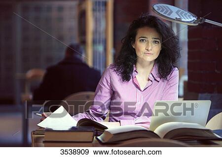Brown-haired young woman in a library. View Large Photo Image Stock Photo - Brown-haired young woman in a library.. Fotosearch