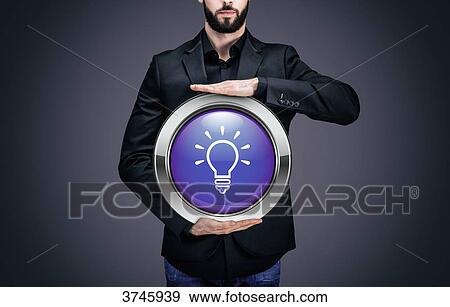 Businessman holding a circle containing the symbol Bulb View Large Photo Image Stock Photo - Businessman holding a circle containing the symbol Bulb. Fotosearch