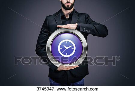 Businessman holding a circle containing the symbol Clock View Large Photo Image Stock Photo - Businessman holding a circle containing the symbol Clock. Fotosearch
