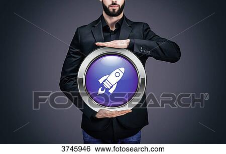 Businessman holding a circle containing the symbol Rocket View Large Photo Image Stock Photograph - Businessman holding a circle containing the symbol Rocket. Fotosearch