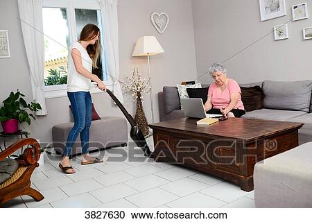 Cheerful young girl helping with household chores elderly woman at home. View Large Photo Image Stock Image - Cheerful young girl helping with household chores elderly woman at home.. Fotosearch