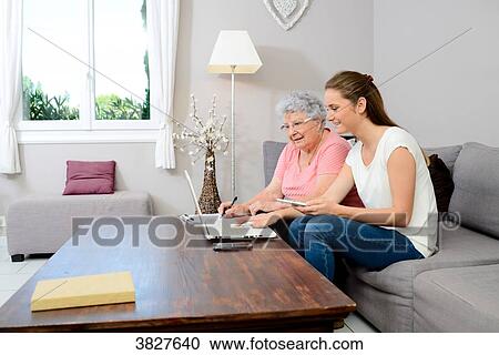 Cheerful young woman helping old person doing paperwork and telephone call. View Large Photo Image Stock Image - Cheerful young woman helping old person doing paperwork and telephone call.. Fotosearch