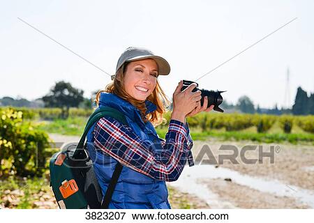 cheerful young woman hiking and taking pictures with her reflex single lens camera- Cepage Grenache, Chateauneuf du Pape, cotes du Rhone, France View Large Photo Image Stock Photo - cheerful young woman hiking and taking pictures with her reflex single lens camera- Cepage Grenache, Chateauneuf du Pape, cotes du Rhone, France. Fotosearch