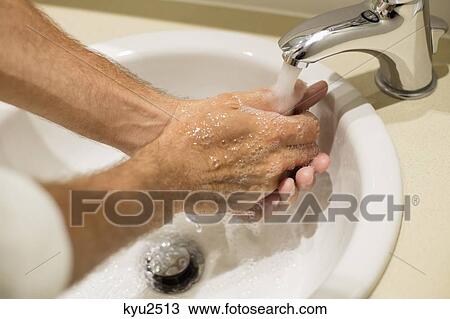 Stock Image - Close-up of a man washing his hands. Fotosearch