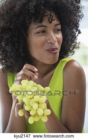 Close-up of a smiling woman eating grapes View Large Photo Image Stock Photo - Close-up of a smiling woman eating grapes. Fotosearch