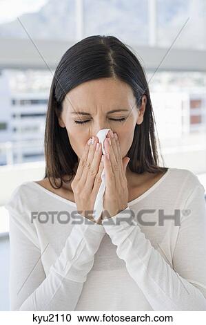 Stock Image - Close-up of a woman sneezing. Fotosearch