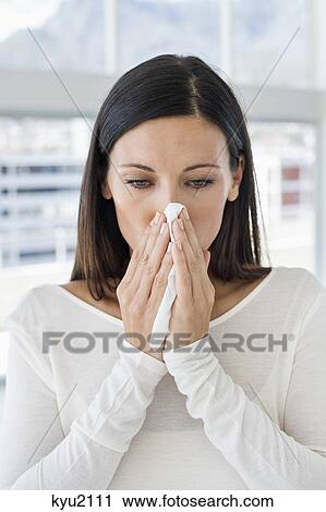 Stock Image - Close-up of a woman sneezing. Fotosearch