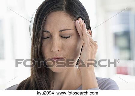 Close-up of a woman suffering from a headache View Large Photo Image Picture - Close-up of a woman suffering from a headache. Fotosearch