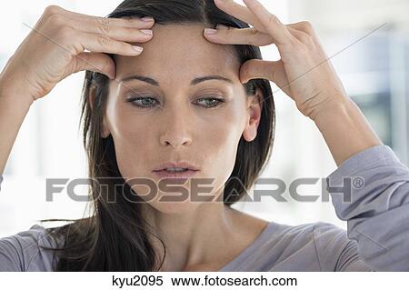 Close-up of a woman suffering from a headache View Large Photo Image Stock Photography - Close-up of a woman suffering from a headache. Fotosearch