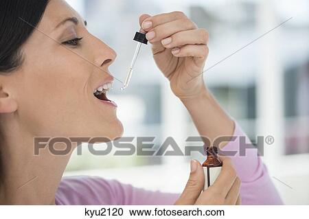 Close-up of a woman taking homeopathic medicine View Large Photo Image Stock Image - Close-up of a woman taking homeopathic medicine. Fotosearch