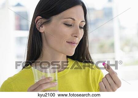 Stock Image - Close-up of a woman taking medicine. Fotosearch