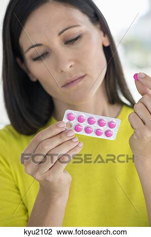 Stock Image - Close-up of a woman taking medicine. Fotosearch