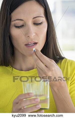 Stock Photo - Close-up of a woman taking medicine. Fotosearch
