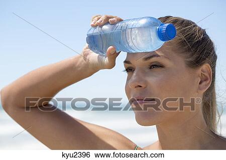 Close-up of a woman with a water bottle View Large Photo Image Stock Photograph - Close-up of a woman with a water bottle. Fotosearch
