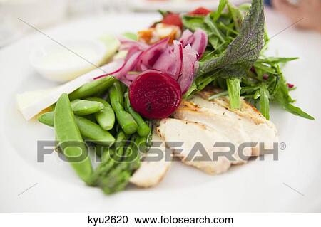 Stock Image - Close-up of green salad with asparagus, beans, onion slices and other vegetables. Fotosearch