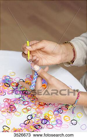 Close-up of hands making elastic bracelets, rainbow loom View Large Photo Image Stock Image - Close-up of hands making elastic bracelets, rainbow loom. Fotosearch