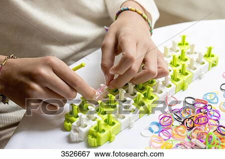 Close-up of hands making elastic bracelets, rainbow loom View Large Photo Image Stock Photo - Close-up of hands making elastic bracelets, rainbow loom. Fotosearch