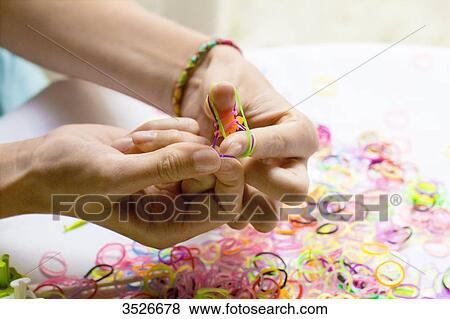 Close-up of hands making elastic bracelets, rainbow loom View Large Photo Image Stock Photo - Close-up of hands making elastic bracelets, rainbow loom. Fotosearch