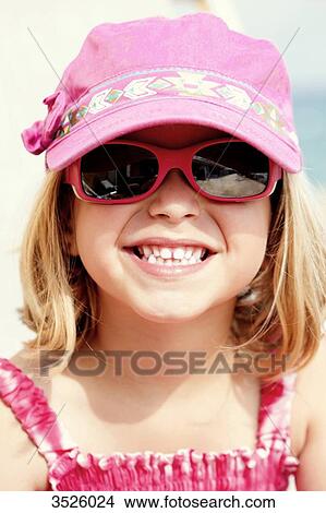 Close-up of little girl smiling with pink sun glasses and cap View Large Photo Image Picture - Close-up of little girl smiling with pink sun glasses and cap. Fotosearch