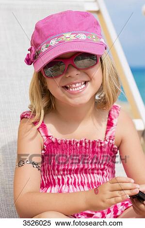 Close-up of little girl smiling with pink sun glasses and cap View Large Photo Image Stock Photography - Close-up of little girl smiling with pink sun glasses and cap. Fotosearch