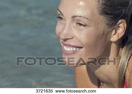 Stock Photography - Close-up of profil smiling blond woman lying in water. Fotosearch