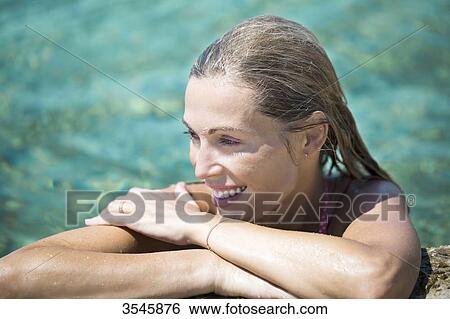 Close-up of smiling young woman in the sea View Large Photo Image Stock Photograph - Close-up of smiling young woman in the sea. Fotosearch