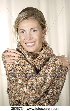 Picture - Close-up of young woman smiling with sweater. Fotosearch