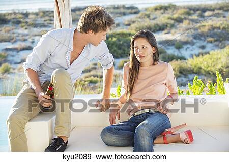 Couple enjoying beer outdoors on a vacation View Large Photo Image Stock Photo - Couple enjoying beer outdoors on a vacation. Fotosearch