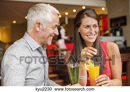 Stock Image - Couple enjoying drinks in a restaurant. Fotosearch
