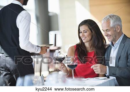 Couple enjoying red wine in a restaurant View Large Photo Image Picture - Couple enjoying red wine in a restaurant. Fotosearch