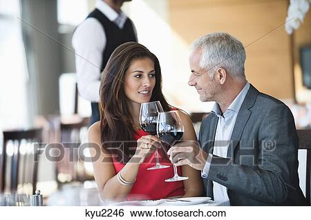 Stock Photograph - Couple enjoying red wine in a restaurant. Fotosearch