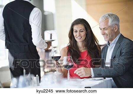 Stock Photography - Couple enjoying red wine in a restaurant. Fotosearch