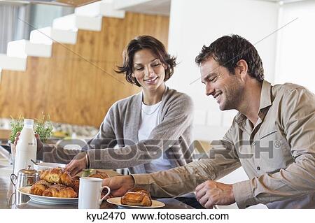 Couple having breakfast at a kitchen counter View Large Photo Image Stock Image - Couple having breakfast at a kitchen counter. Fotosearch