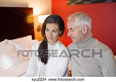 Picture - Couple sitting together in a hotel room. Fotosearch